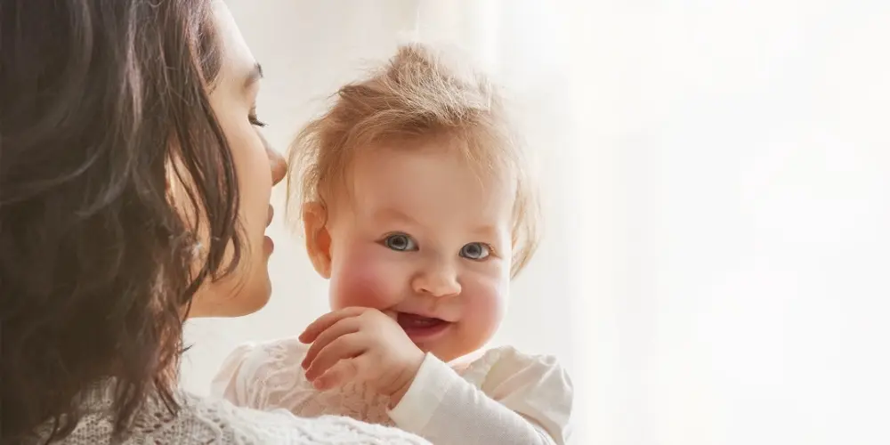 An emotional mother is holding a baby in her arms.