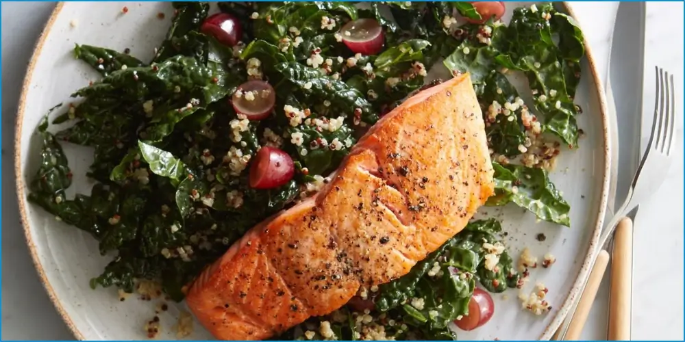 Grilled salmon fillet served over a bed of quinoa and kale salad with cherry tomatoes, perfect for an athlete-friendly, high-protein recipe designed to support performance and recovery.